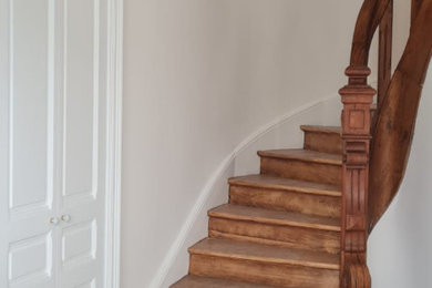 Imagen de escalera curva de estilo de casa de campo grande con escalones de madera, contrahuellas de madera y barandilla de madera