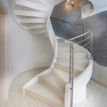 Escalier à vrille en béton avec garde-corps en inox