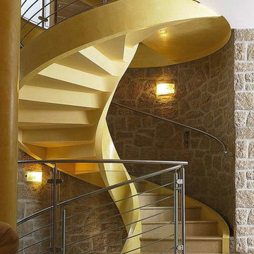 Escalier à vrille en béton et garde-corps en inox et verre