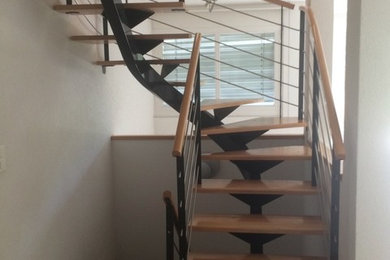 Foto de escalera en U urbana de tamaño medio con escalones de madera y barandilla de metal