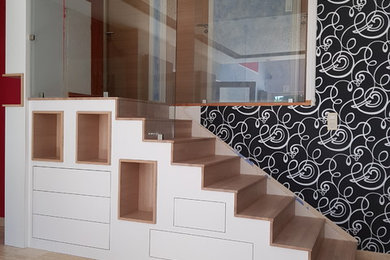 Réalisation d'un escalier droit minimaliste de taille moyenne avec des marches en bois, des contremarches en bois et un garde-corps en verre.