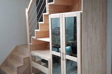 Cette photo montre un escalier moderne en L de taille moyenne avec des marches en bois, des contremarches en bois et un garde-corps en matériaux mixtes.