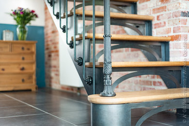 Ejemplo de escalera en L industrial con escalones de madera, contrahuellas de metal y barandilla de metal