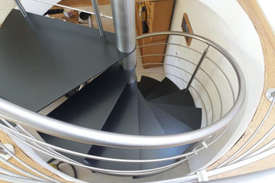 Idée de décoration pour un escalier sans contremarche hélicoïdal design de taille moyenne avec des marches en métal et un garde-corps en métal.