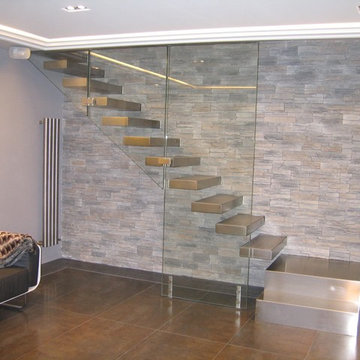 Escalier droit avec marches en bois recouvertes d'inox et garde-corps en verre