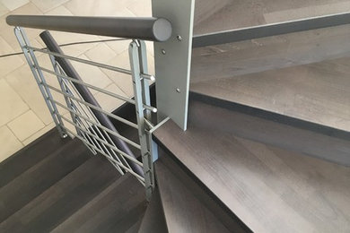 Imagen de escalera en U minimalista de tamaño medio con escalones de madera, contrahuellas de madera y barandilla de metal