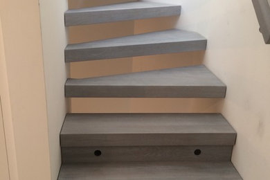 Foto de escalera curva moderna de tamaño medio con escalones de madera y barandilla de madera