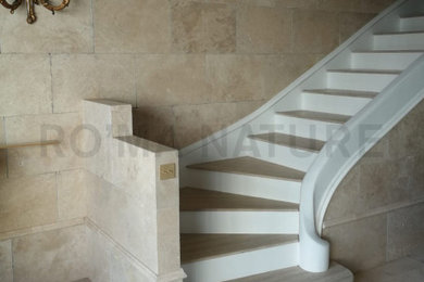 Idée de décoration pour un escalier tradition en L avec des marches en travertin.