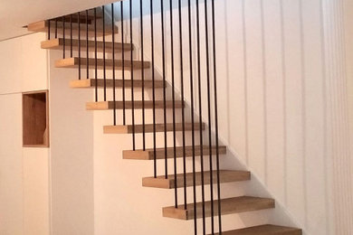 Aménagement d'un escalier sans contremarche droit contemporain avec des marches en bois et un garde-corps en métal.