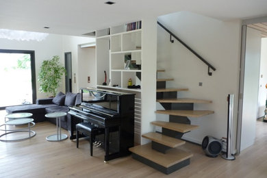 Idée de décoration pour un grand escalier design en U avec des marches en bois.