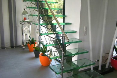 Idées déco pour un escalier sans contremarche droit moderne de taille moyenne avec des marches en verre et un garde-corps en métal.