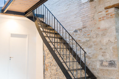 Foto de escalera en L de estilo de casa de campo de tamaño medio sin contrahuella con escalones de metal y barandilla de metal