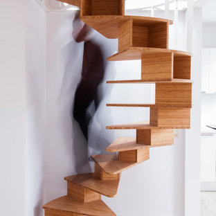 Exemple d'un escalier hélicoïdal tendance avec des marches en bois et des contremarches en bois.