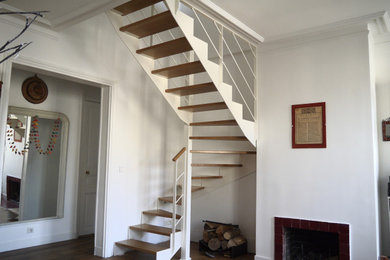 Exemple d'un escalier hélicoïdal tendance de taille moyenne avec des marches en bois et un garde-corps en métal.