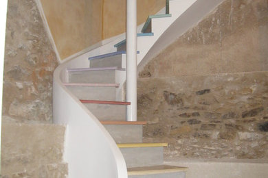 Aménagement d'un escalier courbe contemporain en béton avec des contremarches en béton.