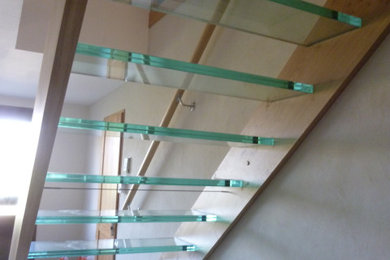 На фото: прямая лестница в современном стиле с стеклянными ступенями с