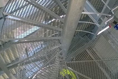 Aménagement d'un escalier sans contremarche hélicoïdal avec des marches en métal.