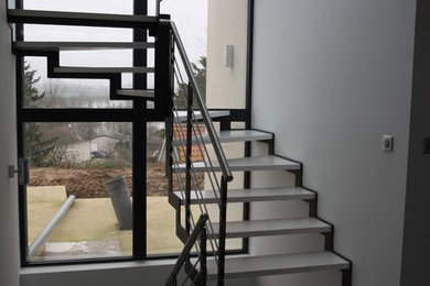 Moderne Holztreppe in U-Form mit offenen Setzstufen in Dijon