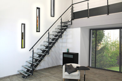 Diseño de escalera recta actual de tamaño medio con escalones de vidrio y barandilla de cable