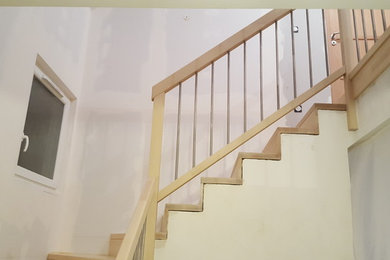 Idée de décoration pour un escalier droit minimaliste de taille moyenne avec des marches en bois, des contremarches en bois et un garde-corps en matériaux mixtes.