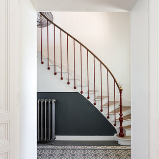 Modelo de escalera curva, moderna, pequeña, con escalones de madera, contrahuellas de madera pintada y barandilla de varios materiales
