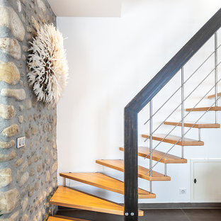 Cette photo montre un escalier sans contremarche tendance en L avec des marches en bois et un garde-corps en métal.