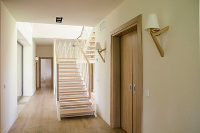 Diseño de escalera en U contemporánea grande sin contrahuella con escalones de madera y barandilla de varios materiales