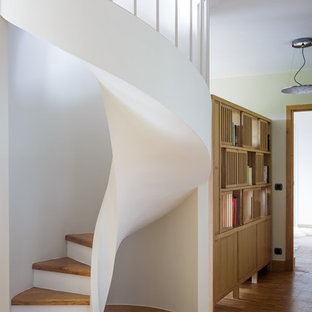 Aménagement d'un escalier hélicoïdal contemporain de taille moyenne avec des marches en bois et des contremarches en bois peint.