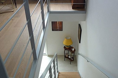 Cette photo montre un escalier tendance en L de taille moyenne avec des marches en bois et un garde-corps en métal.