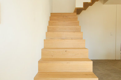 Modelo de escalera en L nórdica de tamaño medio con escalones de madera, contrahuellas de madera y barandilla de madera