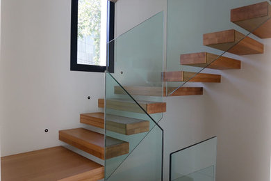 Aménagement d'un escalier flottant contemporain avec des marches en bois.
