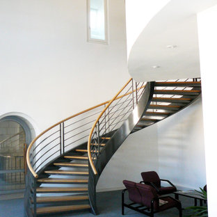 Idée de décoration pour un très grand escalier sans contremarche hélicoïdal méditerranéen avec des marches en bois et un garde-corps en matériaux mixtes.