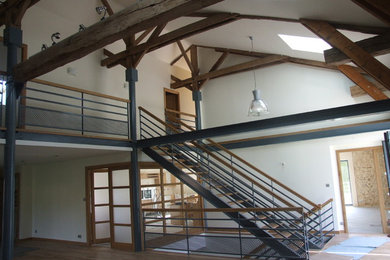Aménagement d'un grand escalier sans contremarche contemporain en U avec des marches en bois.