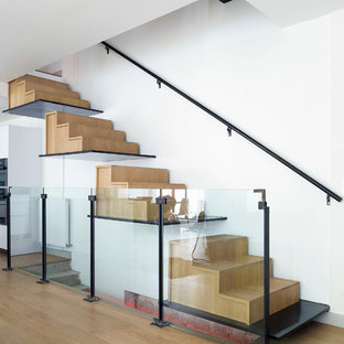Cette image montre un grand escalier flottant design avec des marches en bois et des contremarches en bois.