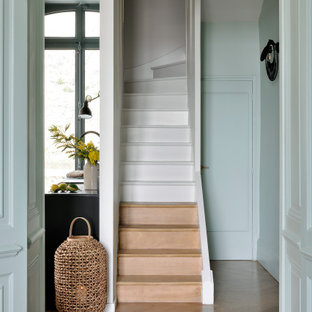 Cette image montre un escalier design en U de taille moyenne avec des marches en bois, des contremarches en bois et un garde-corps en matériaux mixtes.