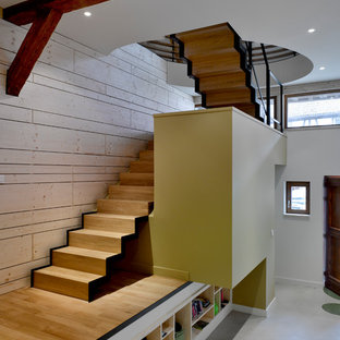 Idée de décoration pour un escalier design en U avec des marches en bois, des contremarches en bois et un garde-corps en métal.