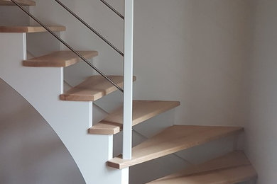 Aménagement d'un escalier contemporain en L de taille moyenne avec des marches en bois et un garde-corps en matériaux mixtes.