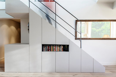 Ejemplo de escalera recta contemporánea de tamaño medio con escalones de madera pintada, contrahuellas de madera pintada y barandilla de metal
