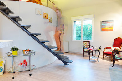 Réalisation d'un escalier courbe design de taille moyenne avec des marches en bois.