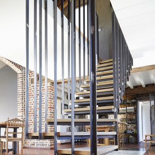 Exemple d'un grand escalier sans contremarche courbe nature avec des marches en bois.