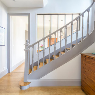 Cette image montre un escalier courbe traditionnel de taille moyenne avec des marches en bois, des contremarches en bois et un garde-corps en bois.