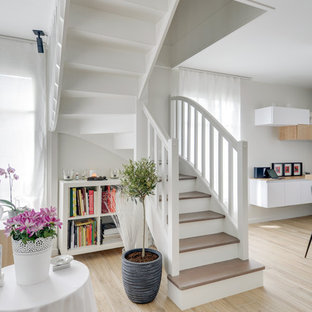 Idée de décoration pour un escalier nordique en L avec des marches en bois, des contremarches en bois peint et un garde-corps en bois.