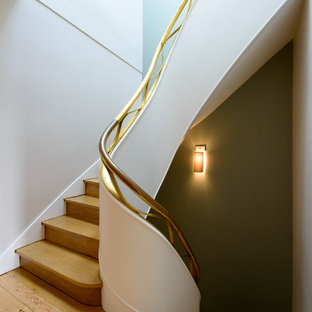 Idées déco pour un escalier courbe classique avec des marches en bois, des contremarches en bois et un garde-corps en métal.