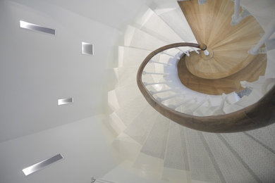 パリにある高級な広いトランジショナルスタイルのおしゃれな折り返し階段 (フローリングの蹴込み板) の写真