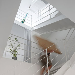 Réalisation d'un grand escalier sans contremarche design en U avec des marches en métal.