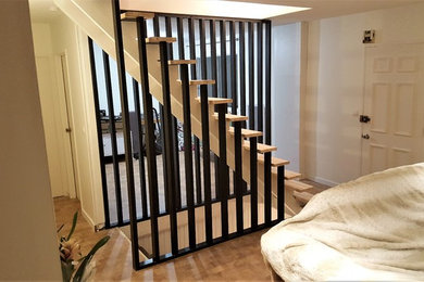 Exemple d'un escalier sans contremarche droit tendance de taille moyenne avec des marches en bois et un garde-corps en métal.
