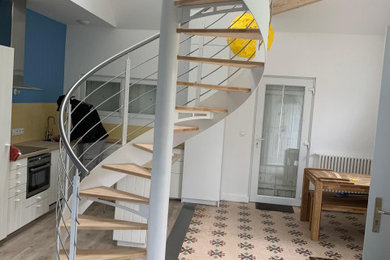 Idée de décoration pour un petit escalier sans contremarche hélicoïdal design avec des marches en bois et un garde-corps en métal.