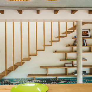 Réalisation d'un grand escalier sans contremarche flottant design avec des marches en bois.