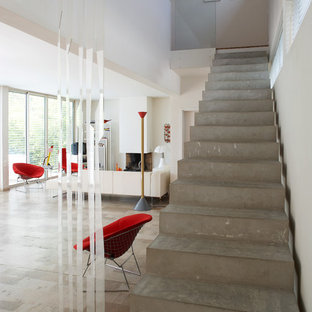 Aménagement d'un grand escalier droit contemporain avec des marches en béton et des contremarches en béton.