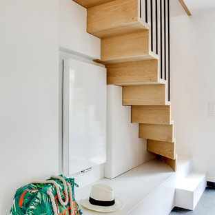 Idée de décoration pour un escalier droit design de taille moyenne avec des marches en bois, des contremarches en bois et des rangements.